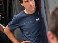 Atleta masculino en entrenamiento de ciclismo, en pausa, en un entorno al aire libre.