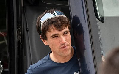 Atleta masculino en entrenamiento de ciclismo, en pausa, en un entorno al aire libre.