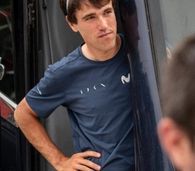 Atleta masculino en entrenamiento de ciclismo, en pausa, en un entorno al aire libre.