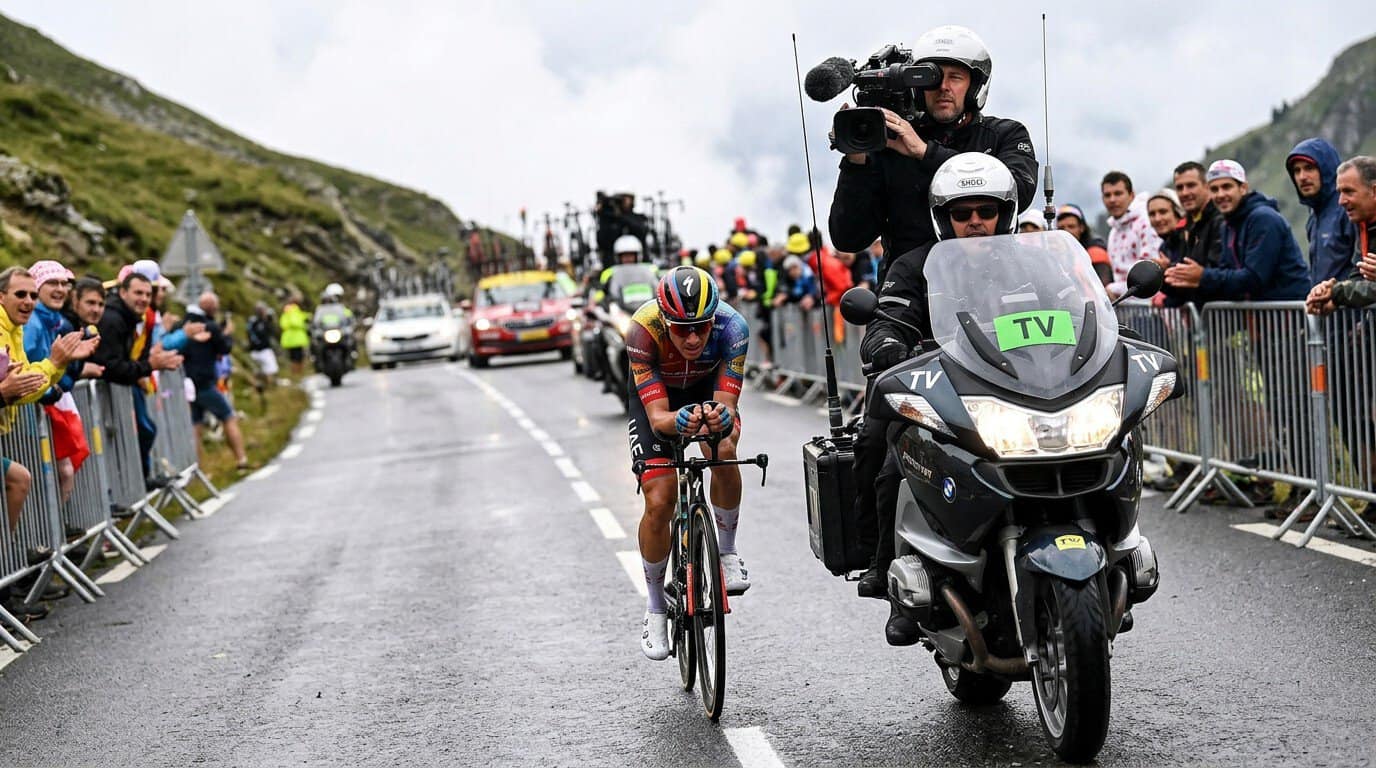 Ciclista profesional rodando detrás de una moto de televisión en una carrera por etapas