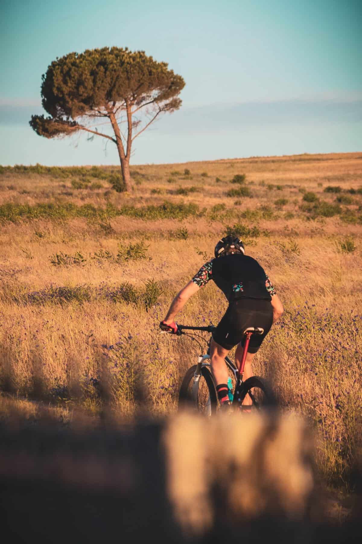 Ciclista MTB bebiendo agua durante una salida en verano — hidratación en bicicleta de montaña con calor