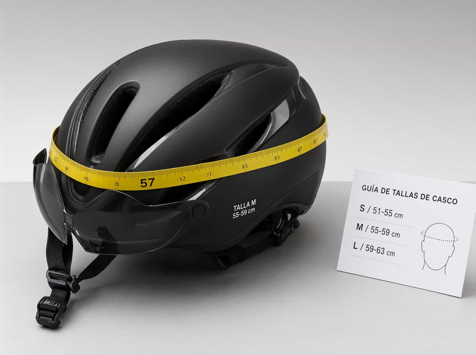 Casco de ciclismo con cinta métrica midiendo la circunferencia de la cabeza y guía de tallas